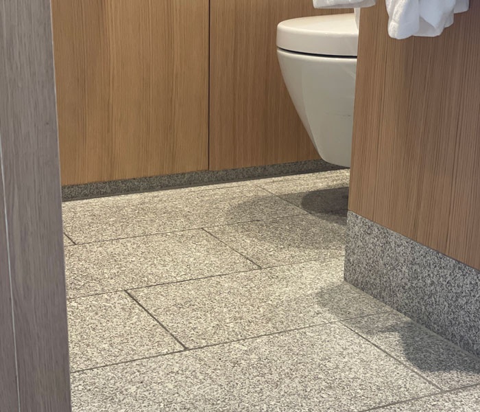 Design hotelier contemporan cum se îmbină granitul cu lemnul și marmura într-o baie elegantă